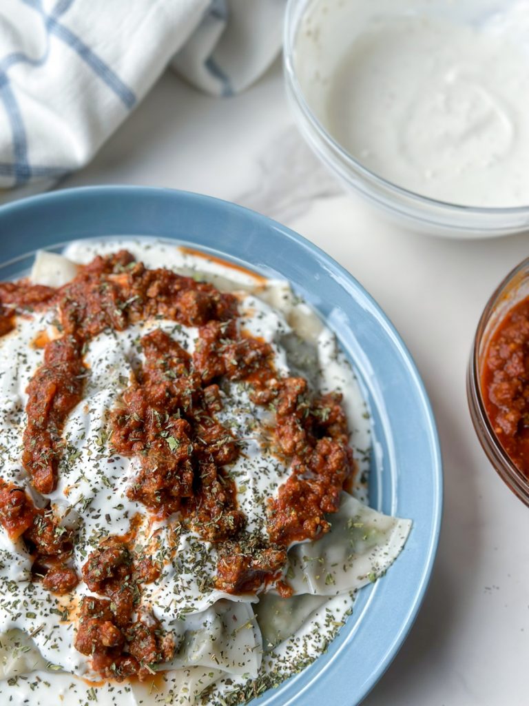 Ashak, a beloved Afghan dish of delicate dumplings filled with leeks and herbs. Served with hearty tomato sauce, creamy garlicky yogurt, and a sprinkle of aromatic dried mint. Savor the goodness of Ashak!