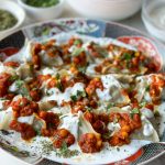 a plate full of Mantu with a sauce being poured over it