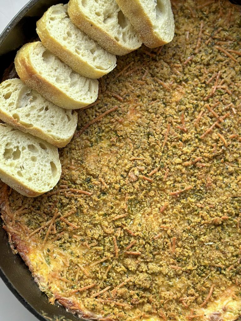 a big pot of jalapeño popper dip with baguettes