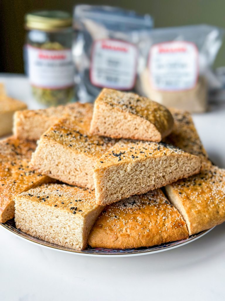 pieces of roht. an afghan sweet bread with white poppy seeds and nigella seeds on top.